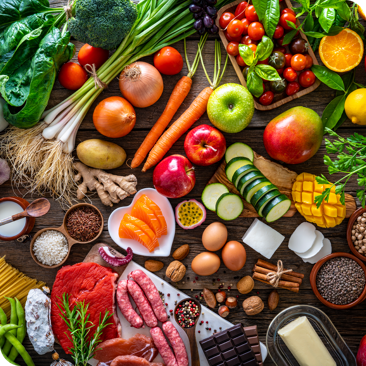 Frische Karotten, Äpfel, Zucchini, Mango, Eier und Nüsse – nährstoffreiche Lebensmittel für gesunde Gelenke.