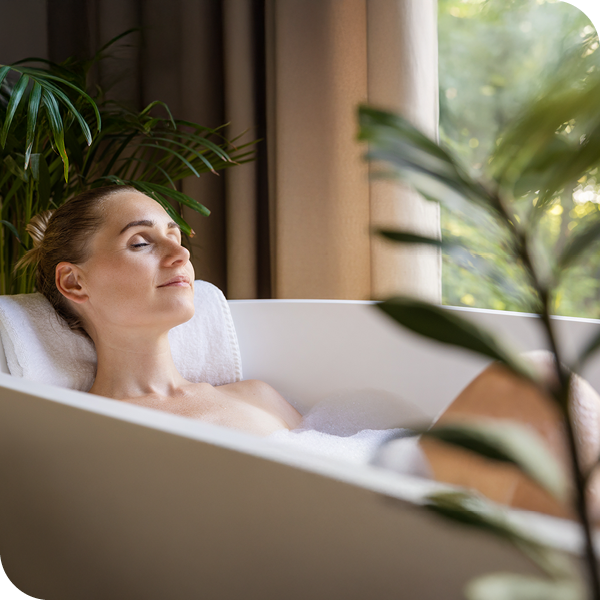 Frau entspannt sich in der Badewanne, um Muskelkater nach dem Sport zu lindern.